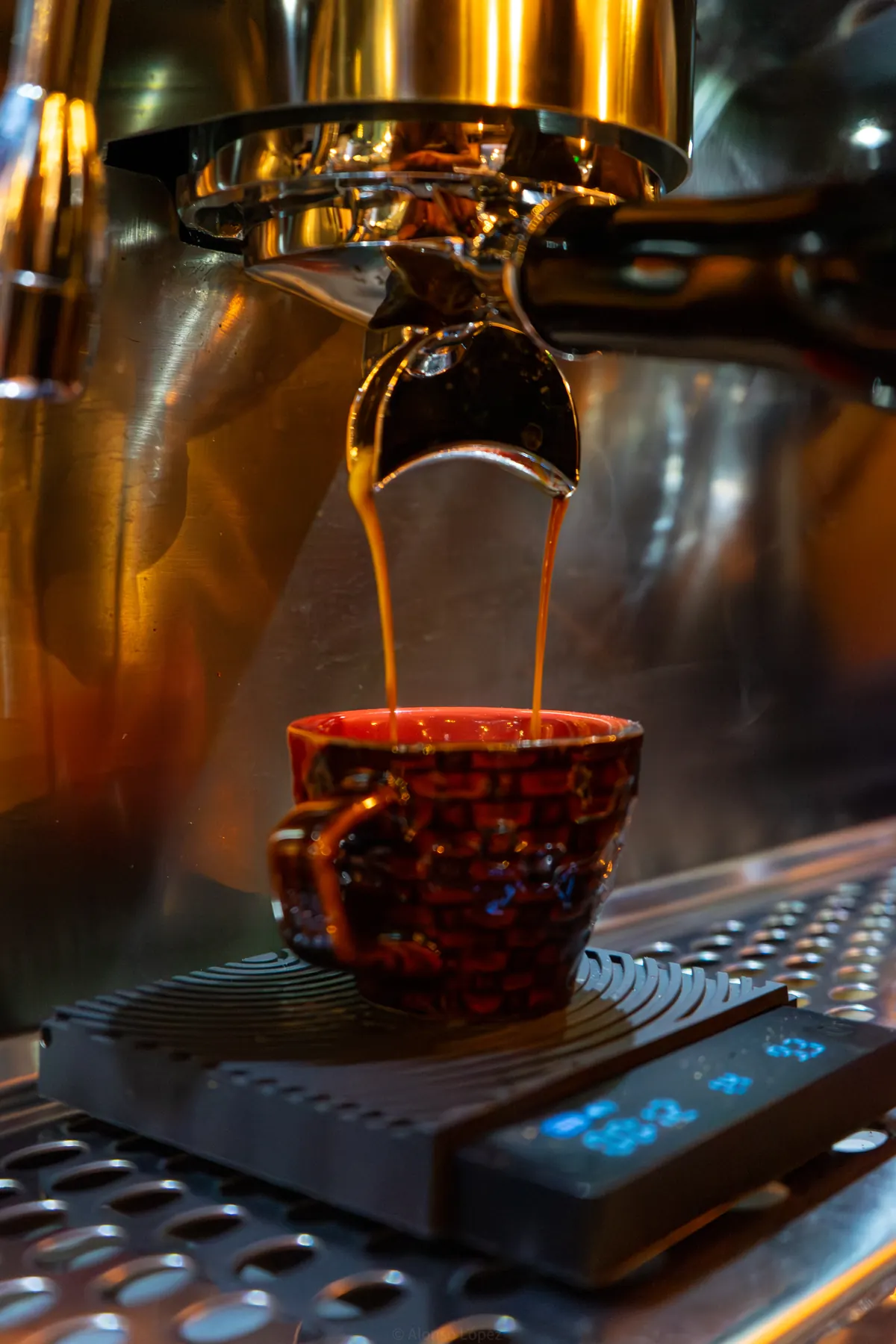 Espresso de especialidad cayendo en una taza roja en Coffeum